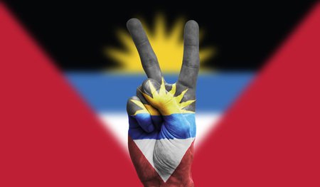 antigua national flag painted onto a male hand showing a victory, peace, strength signの写真素材