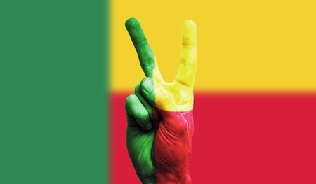 benin national flag painted onto a male hand showing a victory, peace, strength signの写真素材