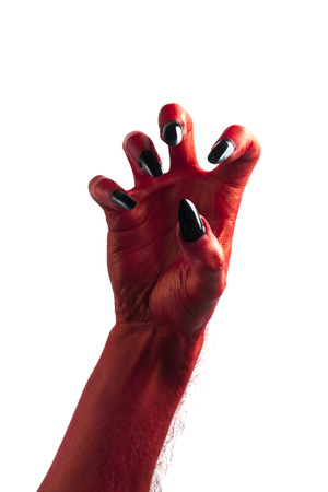 Halloween red devil monster hand with black fingernails against a plain backgroundの写真素材