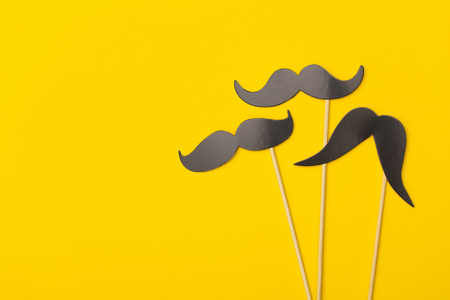 Moustache on a stick on a bright yellow backgroundの写真素材