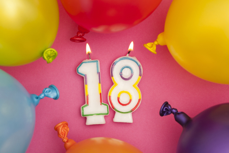 Happy Birthday number 18 celebration candle with colorful balloonsの写真素材