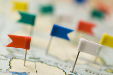 Flag shaped push pin in a vintage travel map. travel destination planning conceptの写真素材