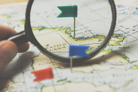 Flag shaped push pin in a vintage travel map. travel destination planning conceptの写真素材
