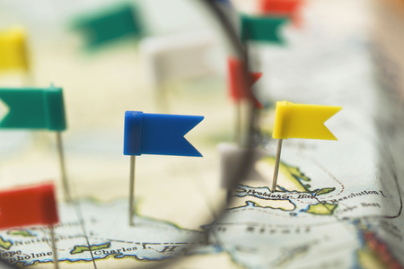 Flag shaped push pin in a vintage travel map. travel destination planning conceptの写真素材