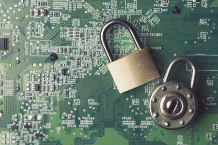 Padlock on a computer electronic circuit board. Technology security conceptの写真素材