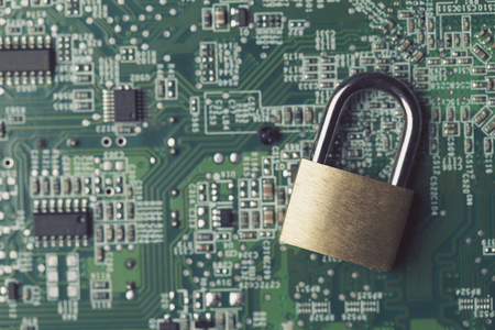 Padlock on a computer electronic circuit board. Technology security conceptの写真素材