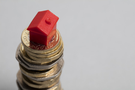 Housing cost. Red house with British currencyの写真素材