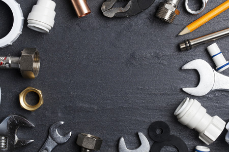 Plumbing concept. tools and pipes on a dark slate bakgroundの写真素材