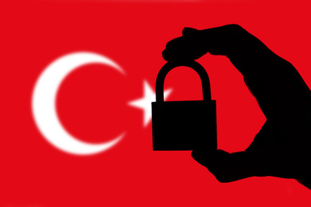 Turkey security. Silhouette of hand holding a padlock over national flagの写真素材