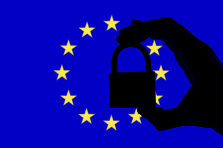 European Union security. Silhouette of hand holding a padlock over national flagの写真素材