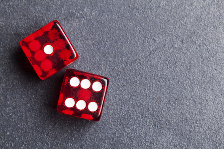 A set of red dice on a slate background. Betting and gambling concept