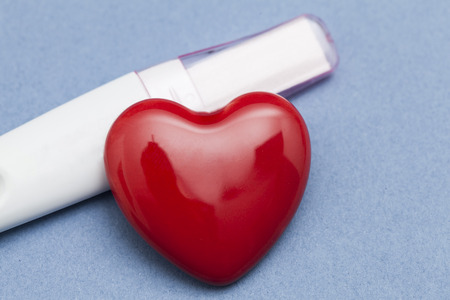Pregnancy test with a red heart on a blue backgroundの写真素材