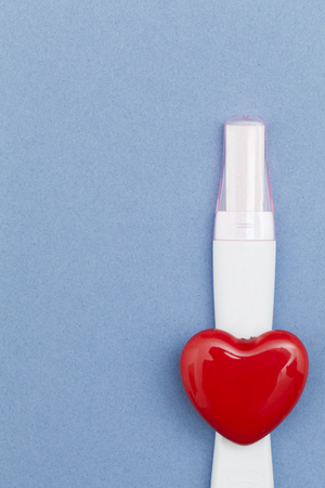 Pregnancy test with a red heart on a blue backgroundの写真素材