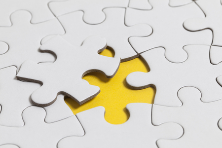 White jigsaw puzzle pieces on a yellow background. Business solution conceptの写真素材