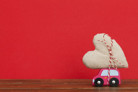 Wodden toy car carrying a love heart. Valentines day, mothers day conceptの写真素材