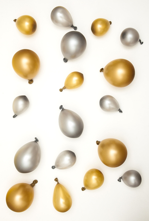 Gold and silver party celebration balloons on a plain backgroundの写真素材