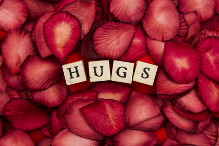 Red rose petals background with romantic hugs messageの写真素材