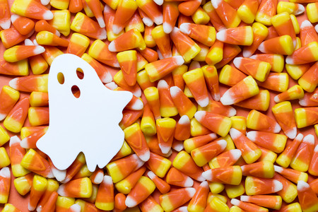 Halloween candy corn background with white ghostの写真素材
