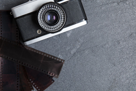 Vintage camera and film negatives on a slate backgroundの写真素材