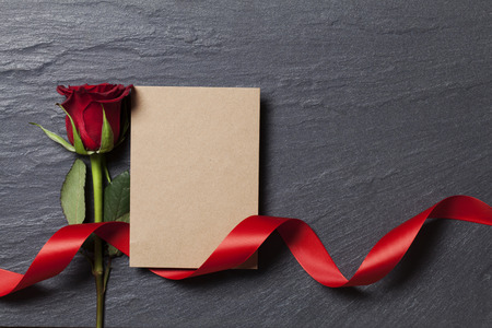 Red rose with a blank card for your messageの写真素材