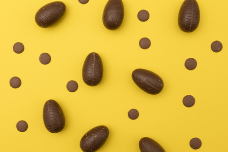 Chocolate easter eggs on a bright yellow background. Easter holiday conceptの写真素材