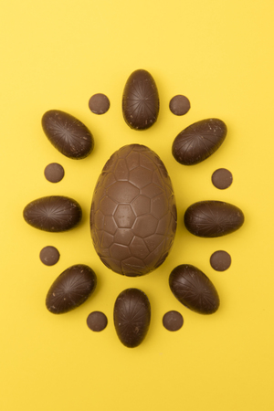 Chocolate easter eggs on a bright yellow background. Easter holiday conceptの写真素材