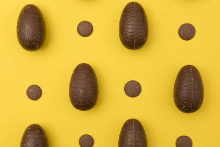 Chocolate easter eggs on a bright yellow background. Easter holiday conceptの写真素材