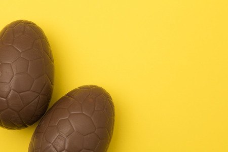 Chocolate easter eggs on a bright yellow background. Easter holiday concept