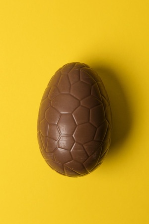 Chocolate easter eggs on a bright yellow background. Easter holiday conceptの写真素材