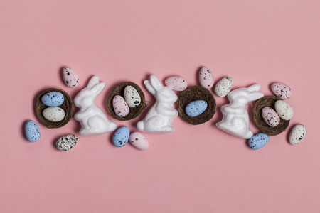 Easter background with easter eggs and easter bunnies on a pink backgroundの写真素材