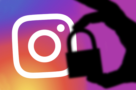LONDON, UK - FEBRUARY 5th 2018: Instagram security concept. Silhouette of a hand holding a padlock...