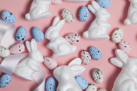Pastel pink easter holiday background with eggs and easter bunniesの写真素材
