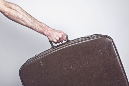Travel concept. Person holding a vintage travel suitcaseの写真素材