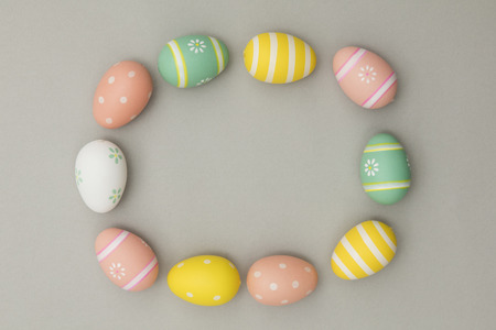 Easter holiday background. Pastel coloured decorated easter eggs on a grey backgroundの写真素材