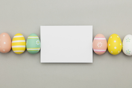Easter holiday background. Pastel coloured decorated easter eggs with a blank white label.の写真素材