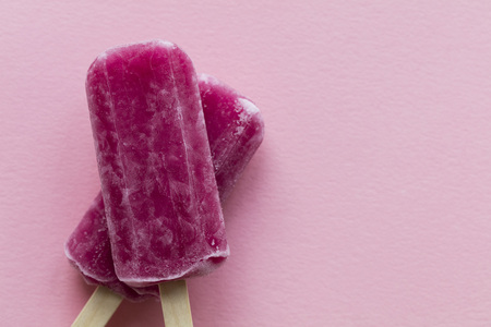 Raspberry flavour summertime ice lollies on a pink backgroundの写真素材