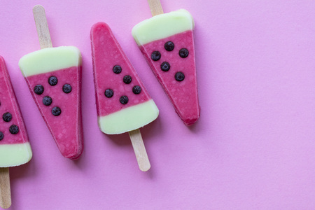 Watermelon shaped summer ice lolly on a pastel pink backgroundの写真素材