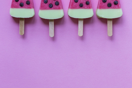 Watermelon shaped summer ice lolly on a pastel pink backgroundの写真素材