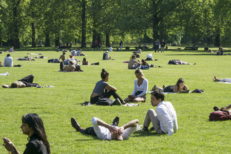 LONDON, UK - MAY 15th 2018: People enjoy the hot sunny weather in Central London by relaxing in the parksのeditorial素材
