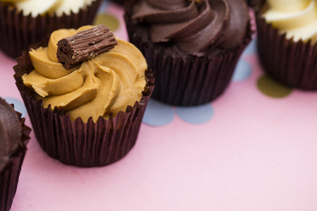 Cupcakes decorated with chocolate,caramel and vanilla icingの写真素材