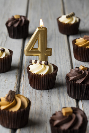 Number 4 celebration birthday cupcakes on a wooden backgroundの写真素材