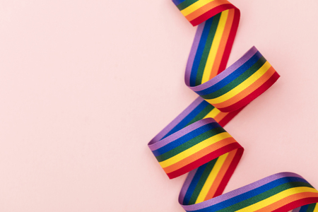 Gay pride LGBT rainbow ribbon on pink backgroundの写真素材