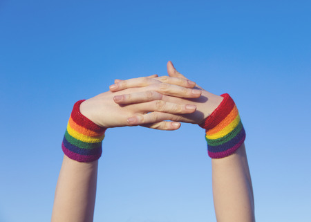 Gay pride concept. Hands with gay pride LGBT rainbow flag wristbandの写真素材