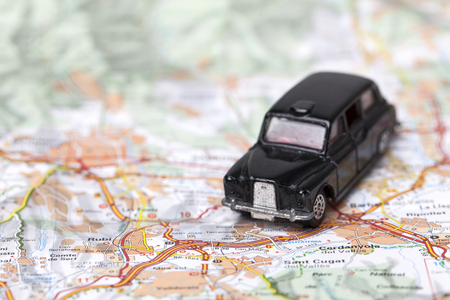 London, UK - MARCH 23rd 2017: A photograph of the Uber logo with a black London style taxi toy car. Uber is a popular taxi style transport service application, founded in 2009のeditorial素材