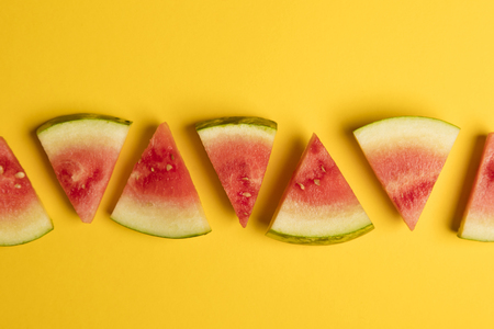Fresh sliced watermelon on a bright yellow backgroundの写真素材
