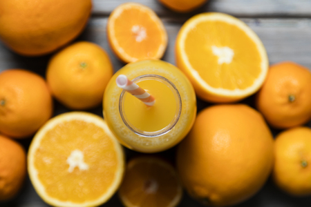 Fresh orange juice in a bottle with oranges on a rustic wooden backgroundの写真素材