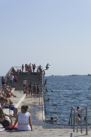 FAABORG, DENMARK - JULY 2018: Swimmers enjoying the harbour bath swimming pier in the town of...
