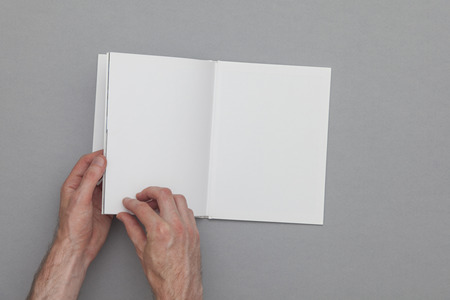 Book mockup. Male hand holding blank book.の写真素材