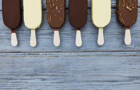 Chocolate ice cream lollies on a wooden background.の写真素材