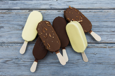 Chocolate ice cream lollies on a wooden background.の写真素材